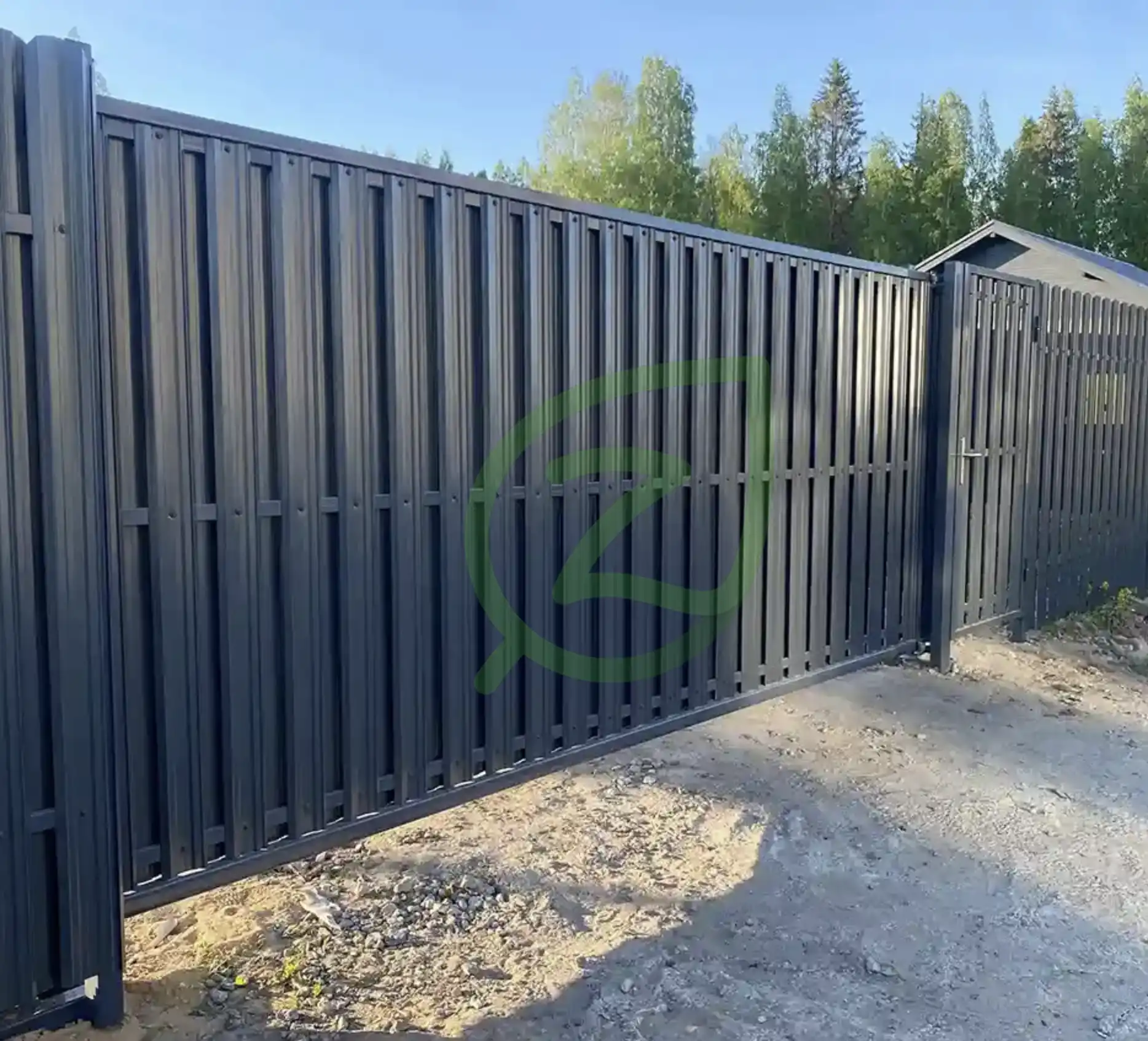 Установлен забор с откатными воротами и серым штакетником 