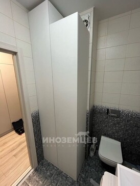 Белый напольный шкаф с закрытыми дверцами в интерьере ванной комнаты