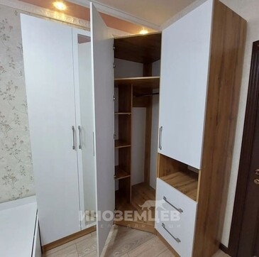 Угловой шкаф с открытой дверью, демонстрирующей систему хранения и выдвижные ящики