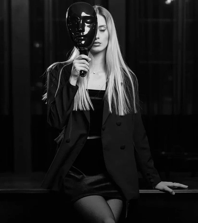 Участница игры Мафия в маске за игровым столом на мероприятии в Минске