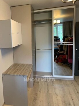 Внутреннее пространство углового шкафа-купе с полками и штангой для одежды
