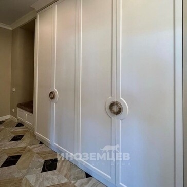 Белый распашной шкаф в прихожую с мягкой банкеткой и стильными ручками