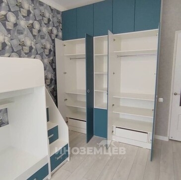 Синий распашной шкаф в детской комнате с открытыми полками и штангами для одежды