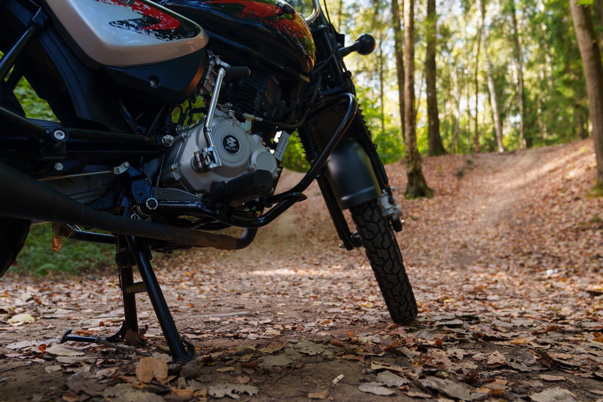 Низкий угол: подчёркнут высокий клиренс и колёса Bajaj Boxer.