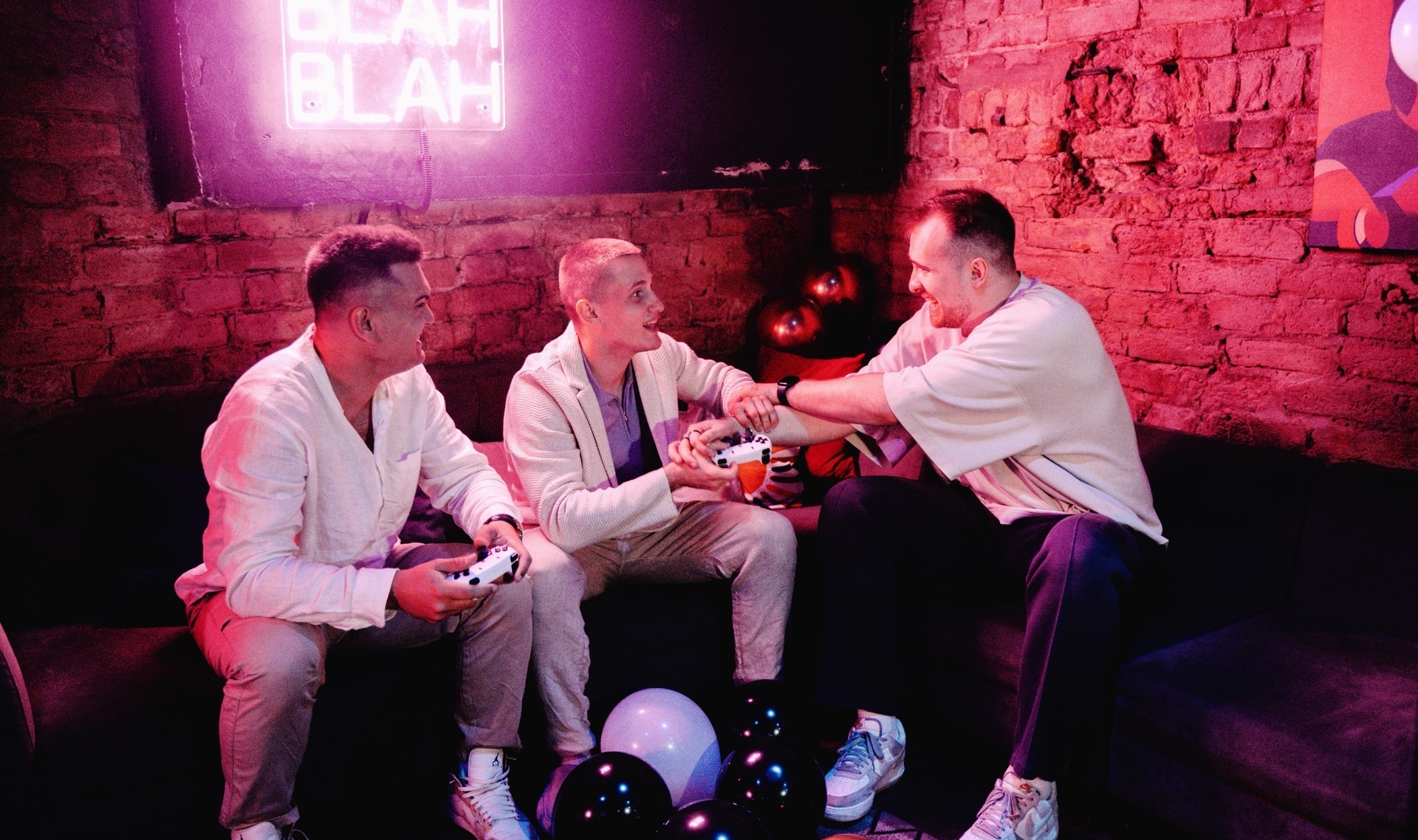 Мужчины играют на приставке на мальчишнике в неоновом лофте, идея для сценария вечеринки
