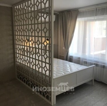 Крупный план геометрического узора белой ажурной перегородки для зонирования спального места