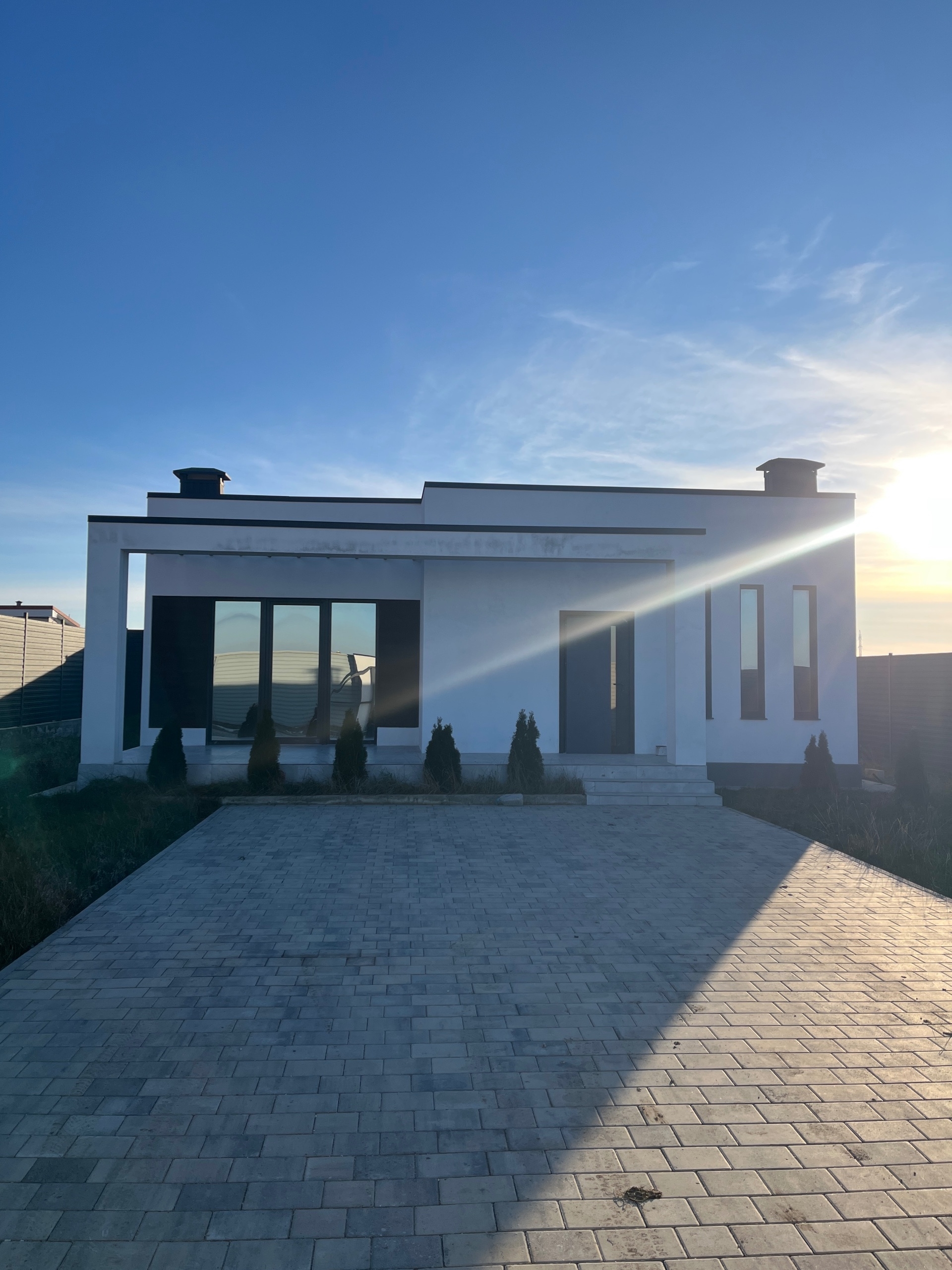 Фото двухэтажного дома с контрастной отделкой, лестницей и балконом