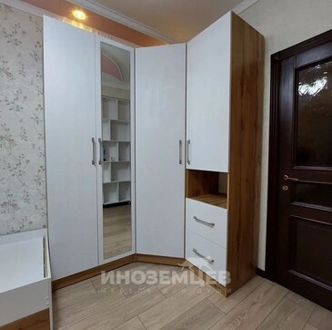 Угловой шкаф в спальню с белыми фасадами и зеркальной вставкой