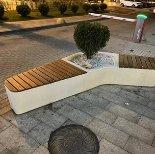 Лавочка с деревянным настилом из архитектурного бетона с цветком внутри на улице