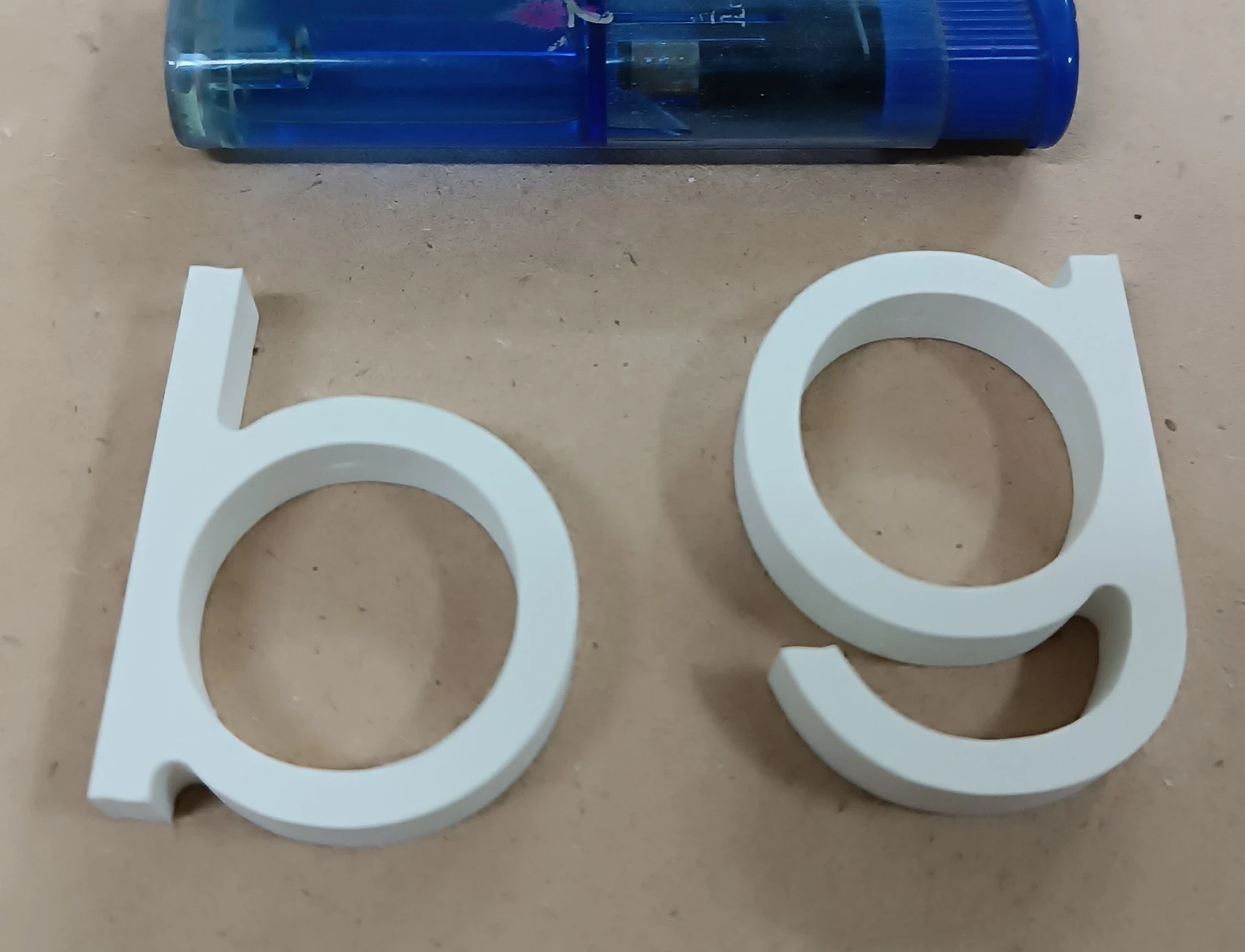 Объемные буквы «b» и «g» из белого пластика, вырезанные на фрезерном ЧПУ станке