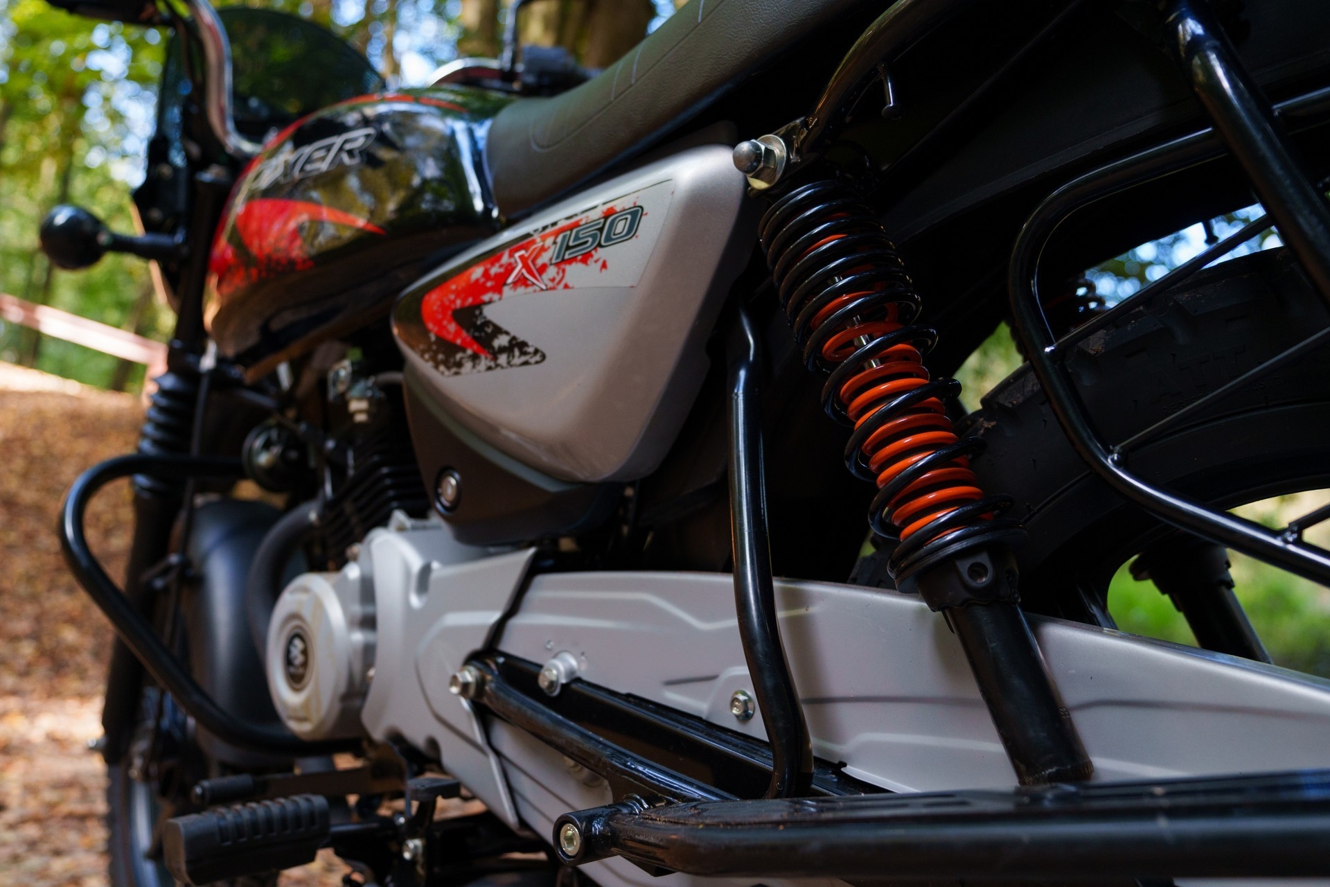 Вид сбоку: крупно задний амортизатор Bajaj Boxer.