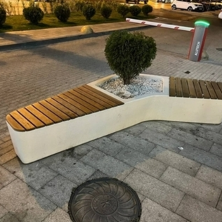 Лавочка с деревянным настилом из архитектурного бетона с цветком внутри на улице