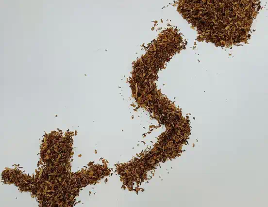 Фото развесного табака, где из него собрали человечка, букву "s" и горсть