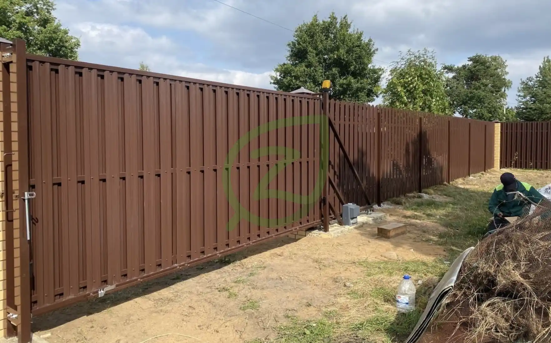 Забор с откатными воротами из коричневого штакетника 