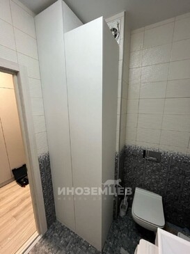 Высокий напольный шкаф-пенал белого цвета в интерьере современной ванной комнаты