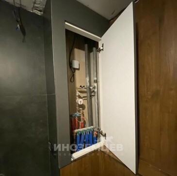 Открытый сантехнический шкаф с трубами и коллектором за дверью МДФ