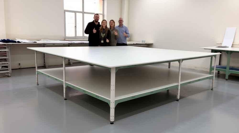 Довольные клиенты у раскройного стола Кутюрье в ателье, большая рабочая поверхность, супер