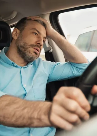 расстроенный водитель сидит за рулем автомобиля