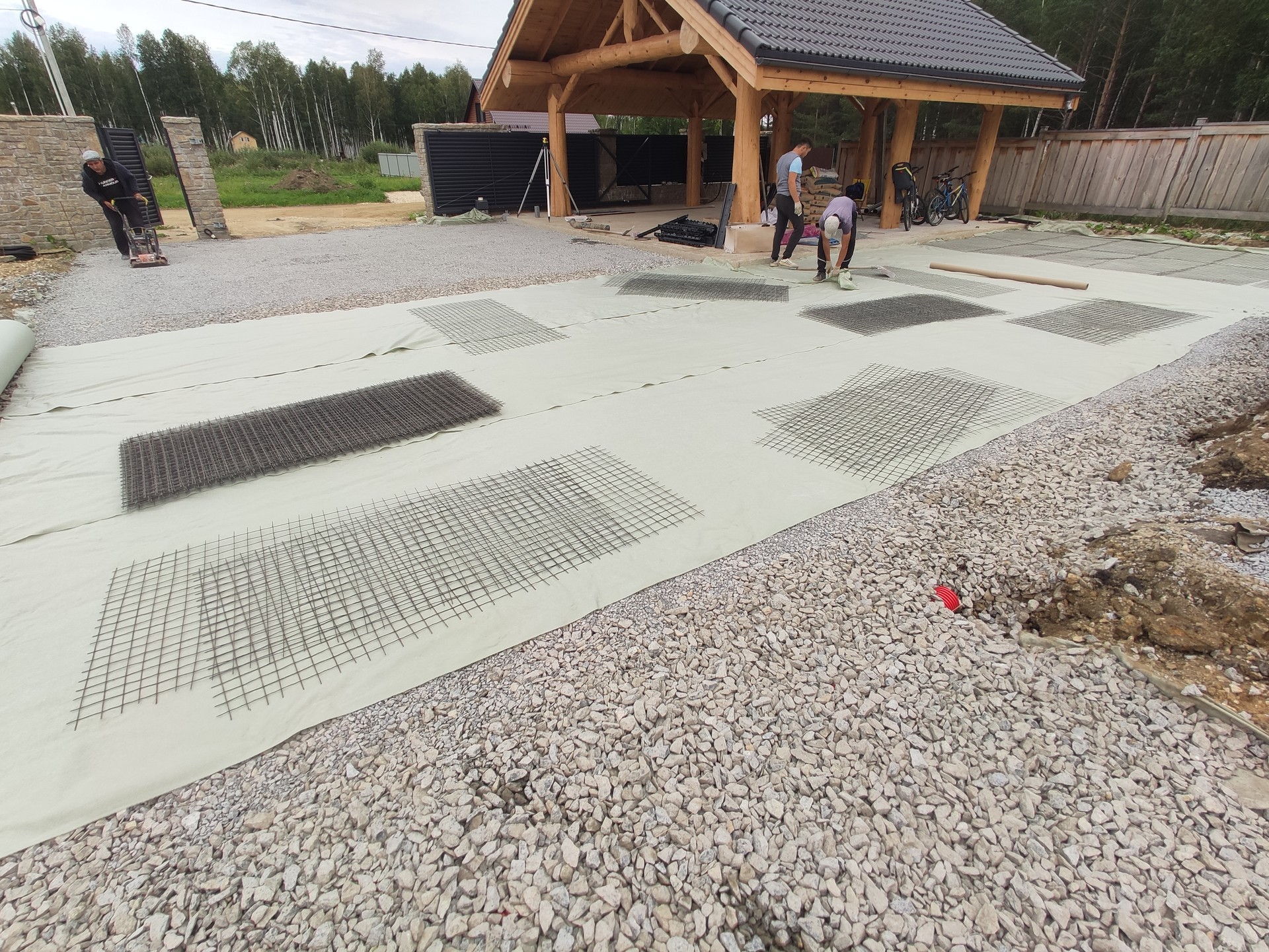 Укладка тротуарной плитки на участке весной — бригада за работой