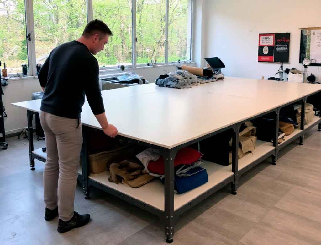 Длинный модульный раскройный стол Кутюрье в мастерской — мастер проверяет удобство