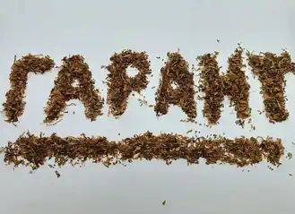 Фотография надписи из табака на развес, на которой написано слово "Гарант"
