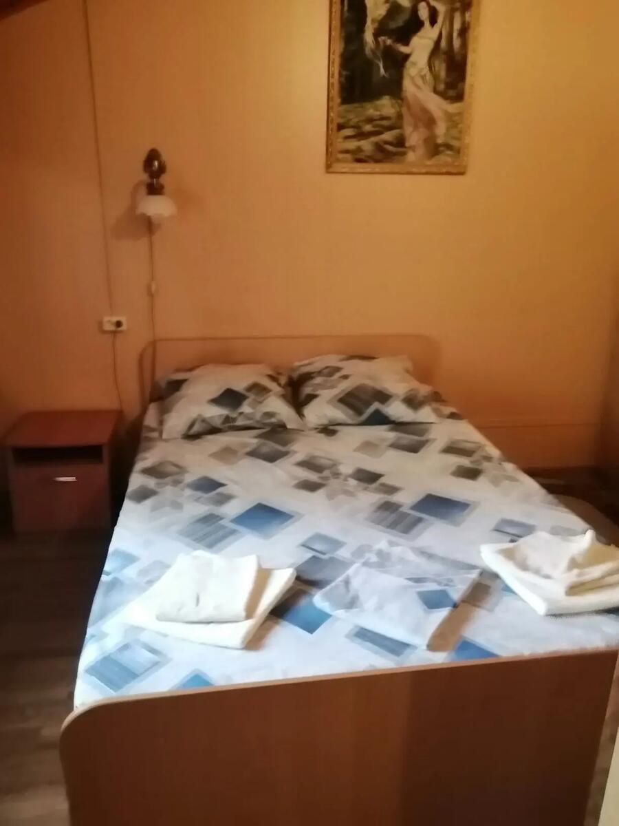 Номер «Люкс» №3: двуспальная кровать, тумбочка, картина на стене