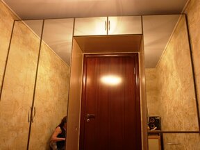 Распашные шкафы и антресоль над дверью с зеркалом