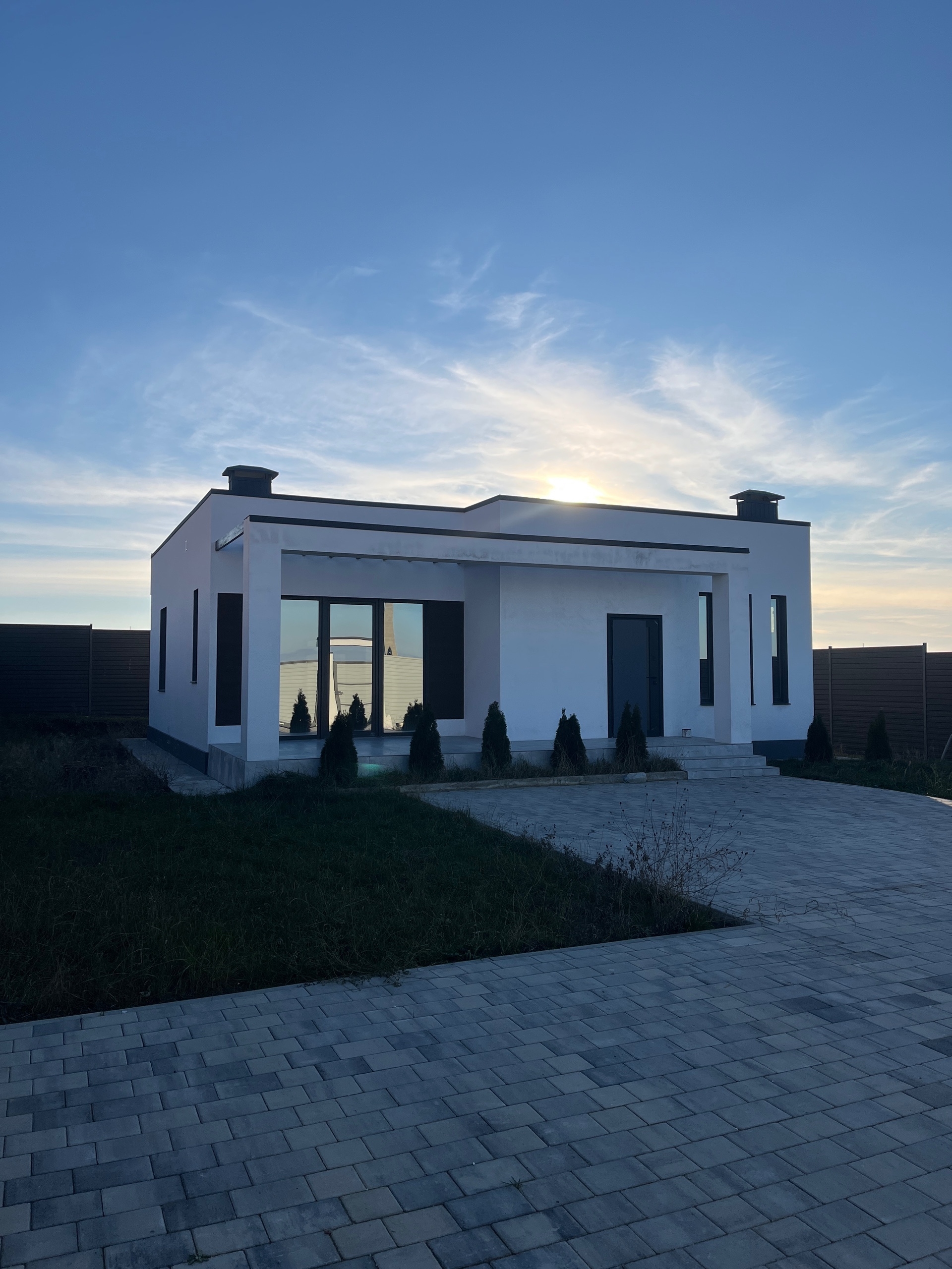 Фото двухэтажного дома с контрастной отделкой, лестницей и балконом